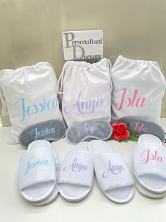 four personalized flip flops are sitting on a counter with two drawsack bags