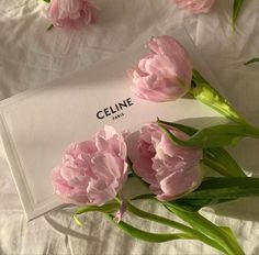 pink flowers are laying on a white sheet with the name celine written on it