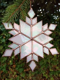 a snowflake ornament hanging from a tree