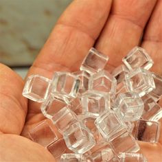 a person holding some clear cubes in their hand