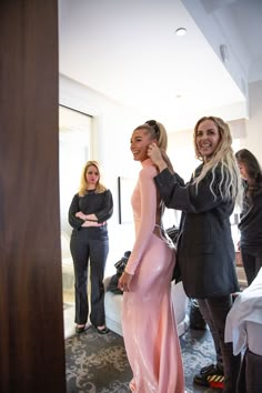 two women are getting ready for a fashion show