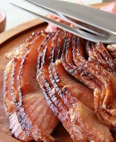 bacon is being sliced on a cutting board with a knife