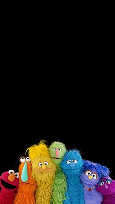 a group of sesame street characters standing in front of a black background