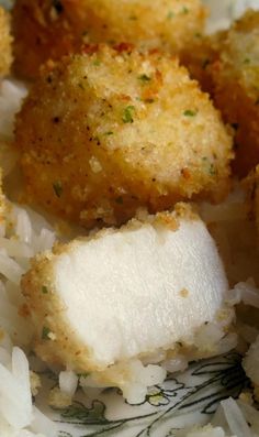 fried fish and rice on a plate with seasoning sprinkled on the side