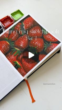 an open notebook with some strawberries on it