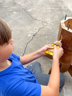 a little boy that is sitting on the ground with some kind of thing in his hand