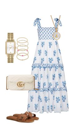 a white dress with blue flowers on it and accessories including sandals, bracelets, watch and purse