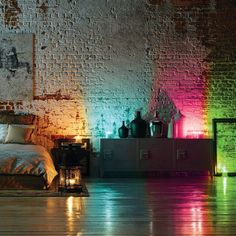 a bedroom with brick walls and colorful lights