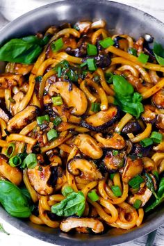 the cover of udon noodle stir fry with mushrooms, garlic, scallions, and basil