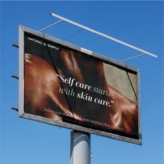 an advertisement for natural & organic skin care is displayed on a street pole in front of a blue sky