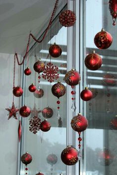 red and gold ornaments hanging from the side of a window