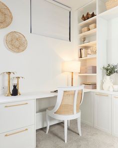 a white desk with two chairs in front of it and some shelves on the wall