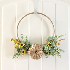 a wreath with sunflowers and greenery hangs on the wall