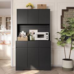 a kitchen area with a microwave, potted plant and cabinets