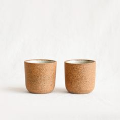 two small cups sitting next to each other on a white surface