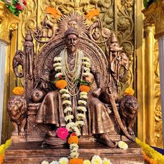 the statue is decorated with flowers and garlands