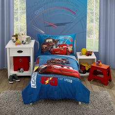 a bedroom with cars bedding and toys on the floor