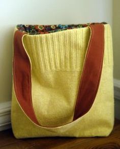 a large yellow bag sitting on top of a wooden floor next to a white wall