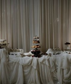 the table is covered with white cloths and pastries