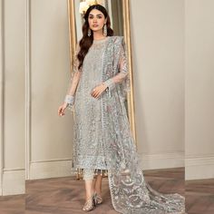 Fabric: Finest Quality Net Same As Picture: Yes 100% Step into the spotlight with the show-stopping Hand Embellished Light Gray Shalwar Kameez! This masterpiece from PK Bridals is not just a dress; it's an experience that promises to transform your special occasions into unforgettable moments. Elegance Elevated Picture this: an extravagant pastel canvas adorned with silver sequins and intricate embroideries that shimmer with every step you take. The Jade Grey Salwar Suit is designed for those who aren't afraid to shine. The mesmerizing floral patterns come alive with the subtle pops of pink and blue in the dupatta, adding an ethereal touch to your ensemble. Luxurious Details Shirt Front & Back: Crafted from premium sequins embroidered net, the shirt exudes sheer elegance. Sleeves: Sequins Net Shirt, Pakistani Wedding Dress, Pakistani Fancy Dresses, Luxury Wear, Embroidered Neckline, Pakistani Dress Design, Pakistani Designers, Shalwar Kameez, Silk Dupatta