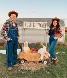 two people in overalls standing next to a chicken coop with chickens on it and a sign that says chicken coop