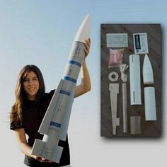 a woman is holding up a model rocket