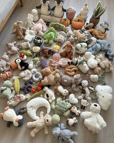 a pile of stuffed animals sitting on top of a wooden floor