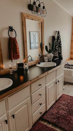 a bathroom with two sinks and a bathtub next to a large mirror on the wall