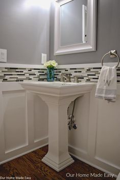 a white sink sitting under a bathroom mirror