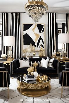 a living room with black and white striped walls, gold accents and chandelier