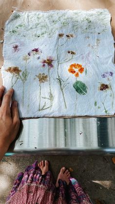 someone is painting flowers on a piece of paper