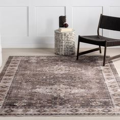 a chair and rug in a room with white walls