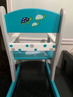 a blue and white wooden rocking chair with turtle decals