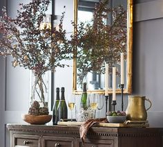 a dining room table with wine glasses and bottles on it, surrounded by other items