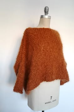 an orange knitted sweater on a mannequin