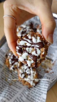 a person is holding up some food on top of a paper towel with chocolate and marshmallows