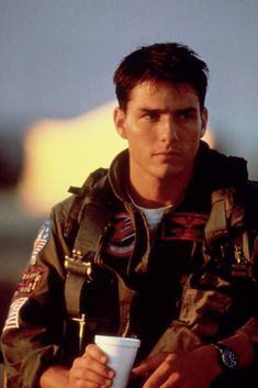 a man in an air force uniform holding a coffee cup