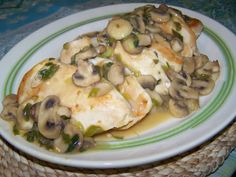 a white plate topped with chicken covered in mushrooms