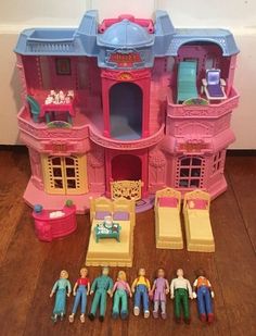 a toy house with dolls and furniture on the floor