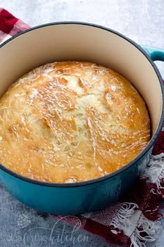 a blue pot filled with bread on top of a red and white checkered table cloth