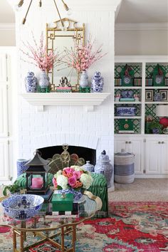 a living room filled with lots of furniture and flowers on top of a coffee table