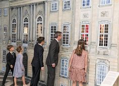 several people standing in front of a building with fake windows and doors on the walls