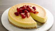 a cheesecake topped with strawberries on a white plate