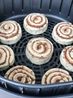 several cinnamon rolls are being cooked in an air fryer