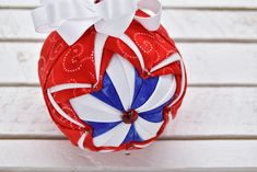 a red, white and blue christmas ornament sitting on top of a wooden table