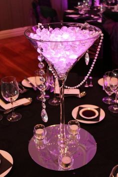 the table is set with wine glasses, silverware and crystal goblets on it