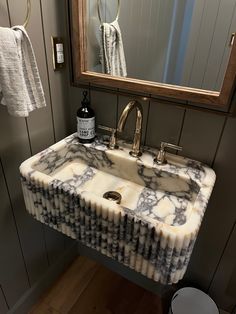 a marble sink in a bathroom under a mirror