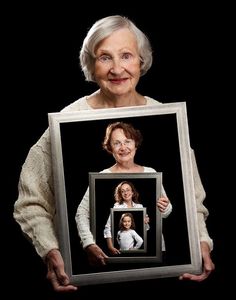 an old woman holding up a framed photo with the words in arabic and english on it