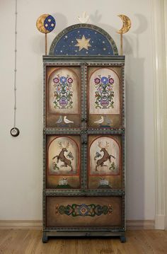 an ornate cabinet with four panels painted on it's sides and decorated with flowers