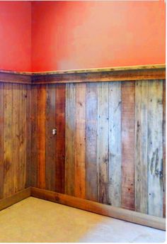 an empty room with wood paneling on the walls and a window in the corner